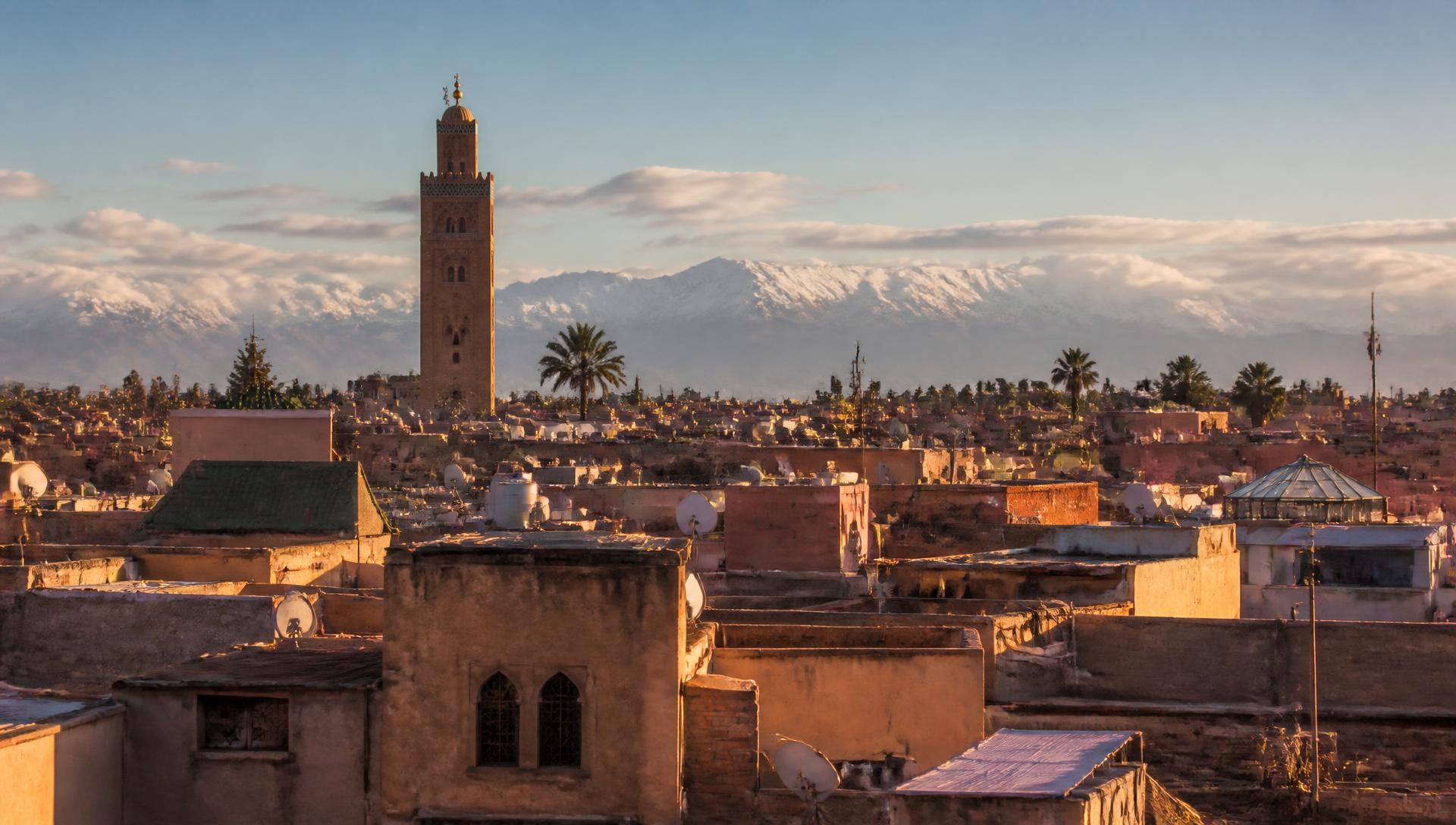 Marrakech medina rooftops at golden hour with the Atlas mountains beyond